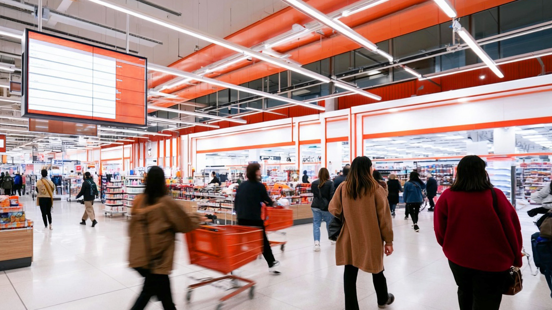Busy retail environment with orange architectural details